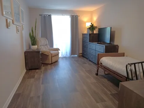 Bedroom with an adjustable bed, recliner, dresser and television