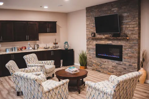 Seating area with chairs, kitchenette and fireplace.