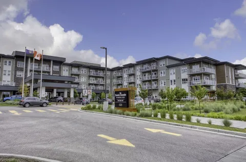 Residence frontage with a covered entrance, balconies and landscaped driveway.