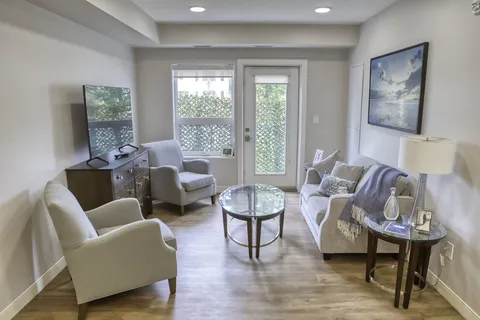 Suite living area with a sofa, chairs and large window.