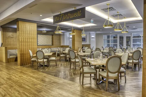 Dining room with set tables, pendant lights and windows.