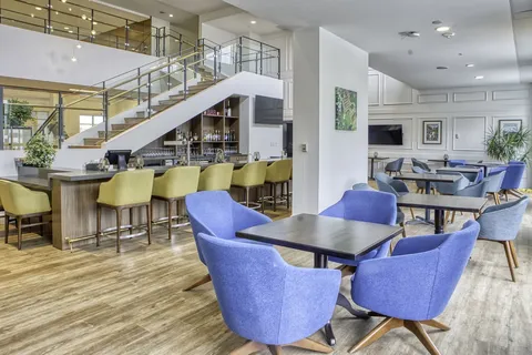 Bistro seating beside a counter and open staircase.