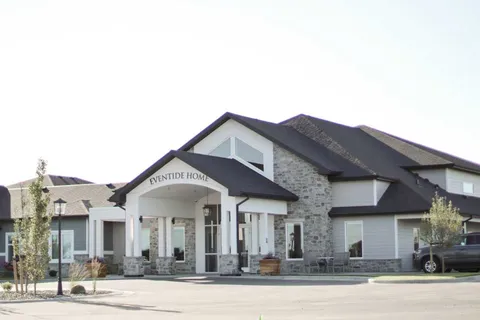 Building entrance with gabled roofs and landscaped beds