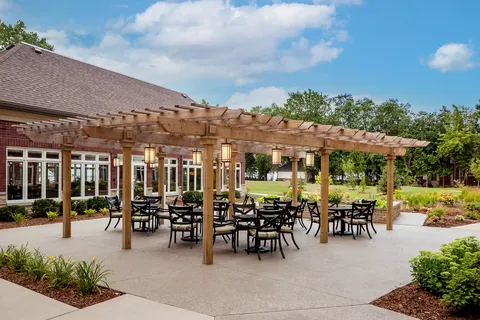 Outdoor tables and chairs beneath a wooden pergola