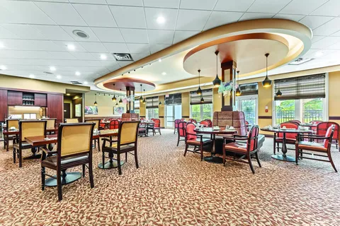 Dining room with tables, upholstered chairs and large windows