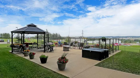 Patio with a gazebo, outdoor chairs, planters and lawns