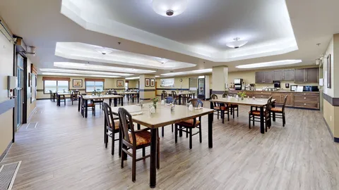 Dining room with wooden tables, chairs and an open kitchen
