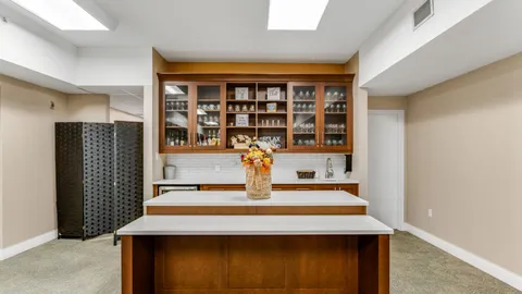 Kitchen counter with an island, a sink and glass-fronted wooden cupboards