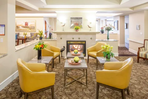 Yellow armchairs and tables around a fireplace