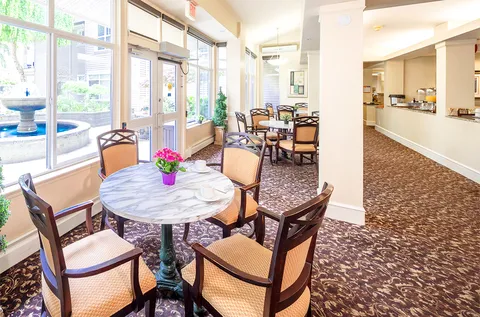 Round tables and chairs beside windows and a serving counter