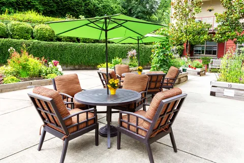 Patio tables and cushioned chairs beneath green umbrellas