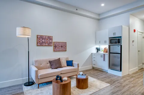Suite sitting area beside a kitchenette and dining nook.