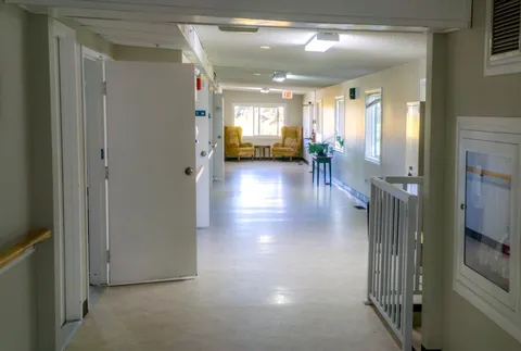 Hallway with doorways and seating at the far end