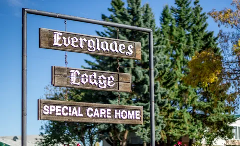 Wooden Everglades Lodge sign hanging between metal posts