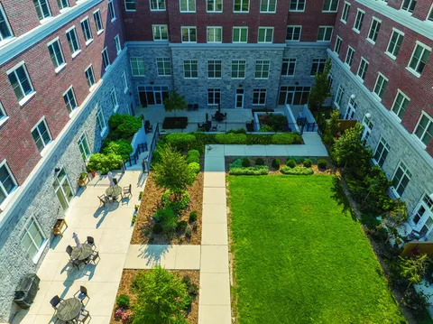 Aerial view of a courtyard with paths, lawn and patio tables