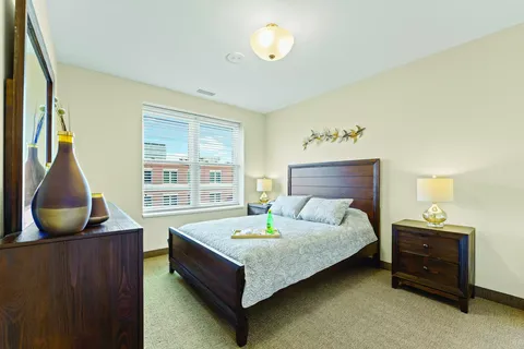 Bedroom with a wooden bed, bedside tables and a large window