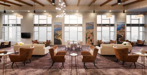 Room with sofas, armchairs, round tables and large windows