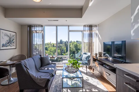 Suite living room with a sofa, television and balcony doors.