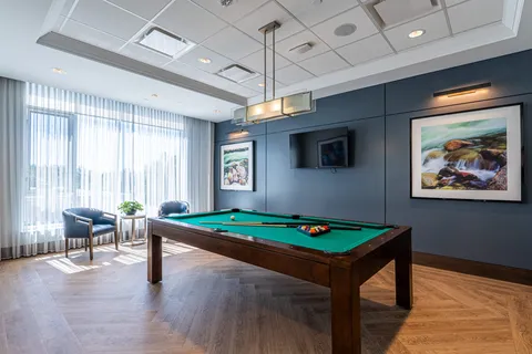 Billiards room with a pool table and window seating.