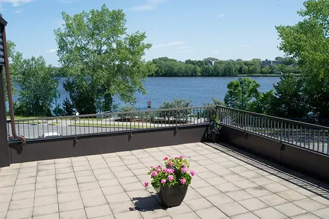 Outdoor terrace with chairs overlooking the river.