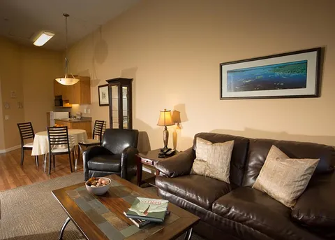 Suite sitting and dining area with a sofa, armchair and table.