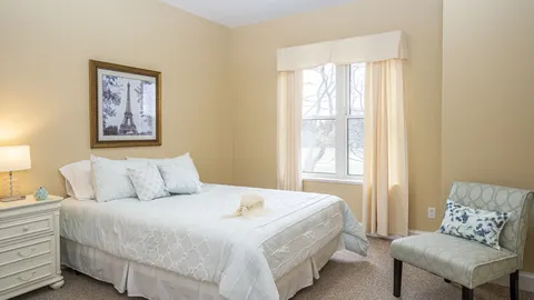 Bedroom with a bed, bedside table and an armchair