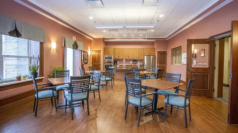 Room with tables, chairs and a kitchen counter
