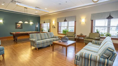 Room with striped sofas, armchairs and a pool table