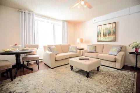 Apartment sitting and dining area with a sofa and armchairs.