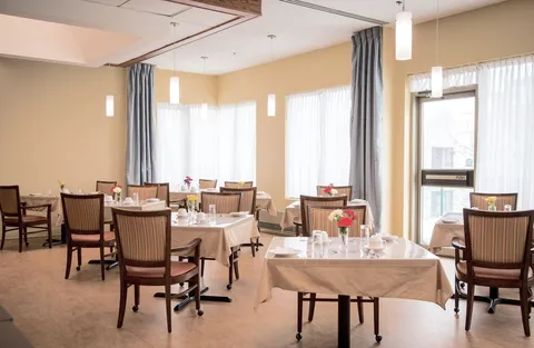 Dining room with tables, chairs and large windows.