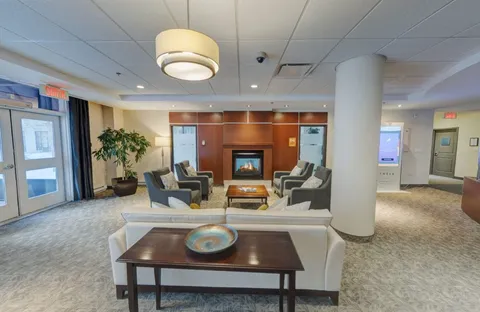 Armchairs and a sofa facing a fireplace beside glass doors