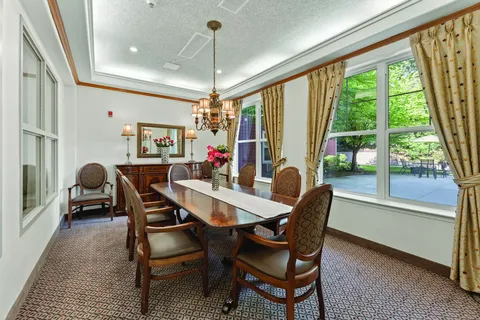 Private dining table beside large windows and a chandelier
