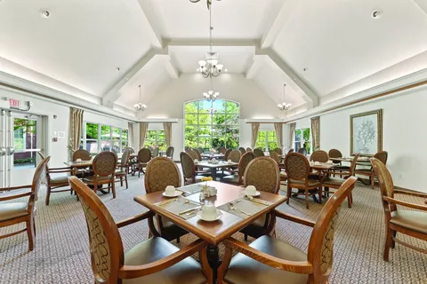 Dining room with set tables, patterned chairs and high windows