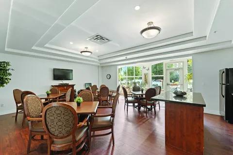 Tables and patterned chairs beside a counter and large windows