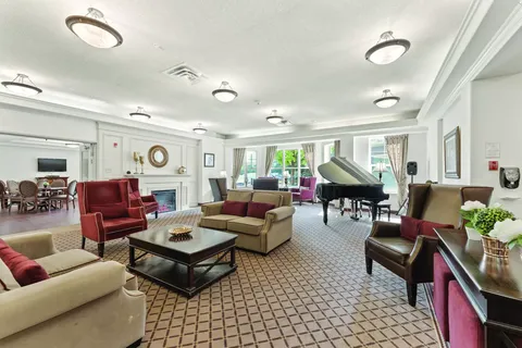 Lounge with sofas, armchairs, a grand piano and fireplace