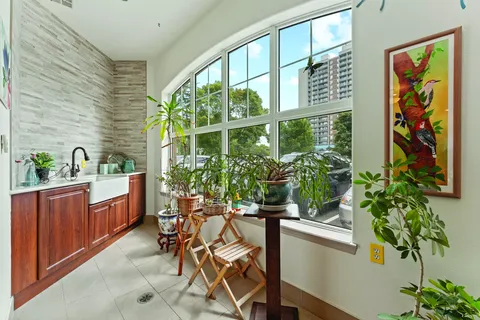 Room with plants, a potting counter, sink and large curved windows