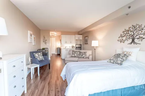 Studio room with a bed, sofa, armchair and kitchenette