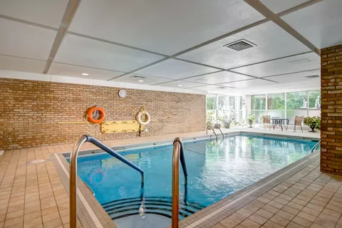 Indoor swimming pool with brick walls, tiled surround and large windows