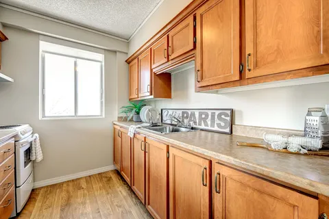 Kitchen with wood cupboards, a countertop and a window