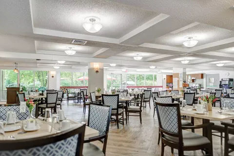 Dining room with set tables, patterned chairs and large windows