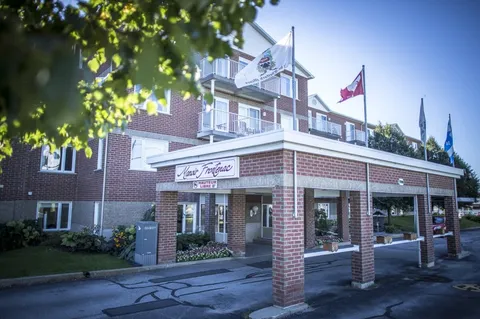 Brick residence entrance with a wide canopy and flags