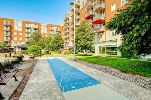 Outdoor shuffleboard court beside gardens and the residence