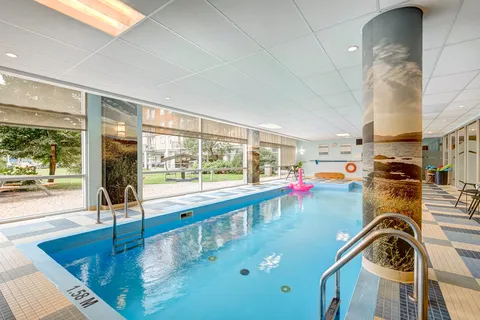 Indoor swimming pool beside large windows