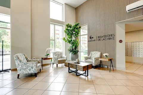 Lobby with armchairs, tables, plants and mailboxes