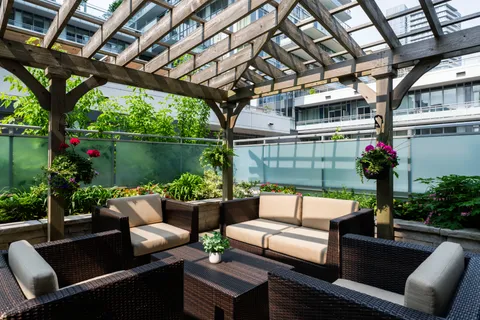 Patio lounge beneath a wooden pergola.