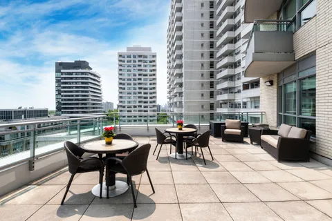 Terrace with outdoor tables, chairs and a glass railing.