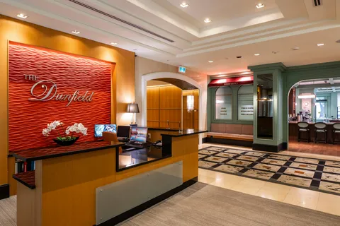 Reception desk and lobby with patterned flooring and seating.