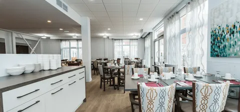 Dining room with set tables, upholstered chairs and patterned wall art