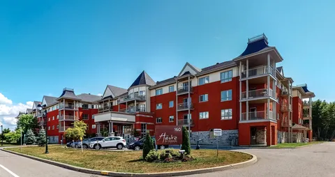 Red and cream residence with balconies, a covered entrance and a sign marked 160