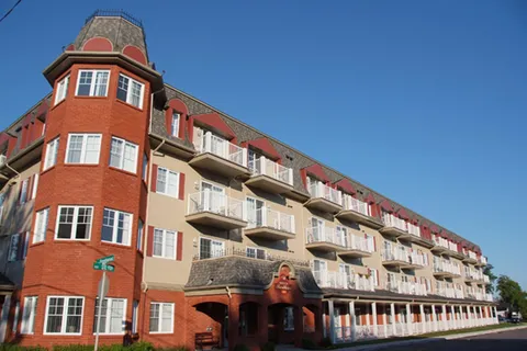 Residence with a red-brick corner tower, white balconies and a long front veranda